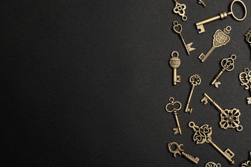 Flat lay composition with bronze vintage ornate keys on dark background, space for text - obrazy, fototapety, plakaty