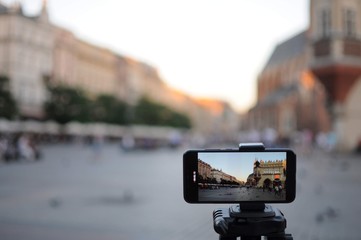 Close-up smartphone take cityscape photo and video timelapse on tripod. 