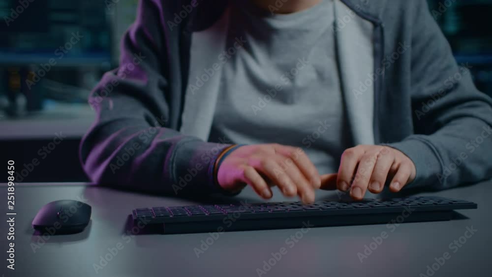 Poster Anonymous Software Developer / Hacker Sitting at His Desk and Typing on Computer Keyboard. Neon Technological Background. POV Camera Shot