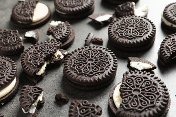 Tasty chocolate cookies with cream on grey background