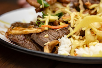 Asian cuisine. Cooked in a wok delicious rice with vegetables and meat served in a plate.