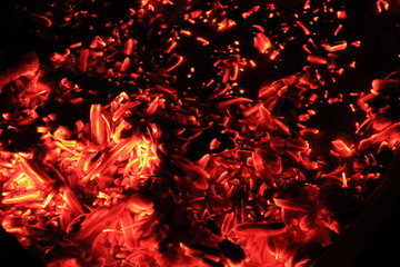 Bright red and orange embers of bonfire at night. Beautiful fiery natural background