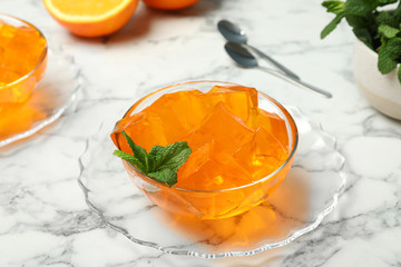 Orange jelly in bowl on marble table - obrazy, fototapety, plakaty