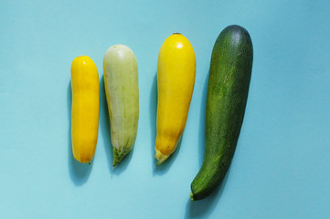 Assorted fresh multicolored zucchini on a blue background