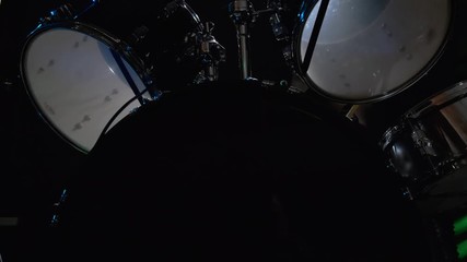 Girl drummer banging on a drum kit on stage.