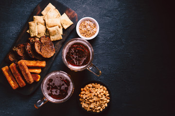 beer and snacks. bar table. restaurant, pub, food concept. craft lager drink, salted nuts and breaded fried cheese. friday party atmosphere, craft brewery background