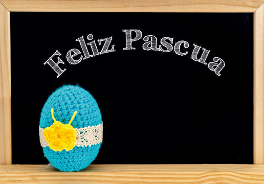 Easter frame with painted eggs and chalkboard. Happy Easter in white chalk. Happy Easter in spanish : feliz Pascua