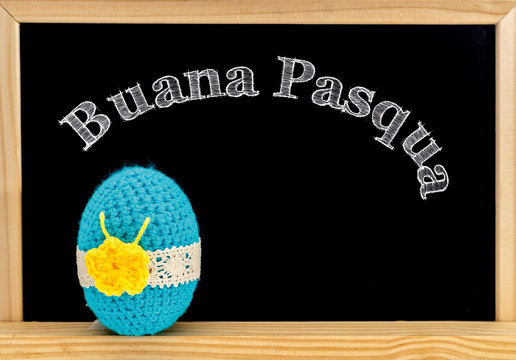 Easter frame with painted eggs and chalkboard. Happy Easter in white chalk. Happy Easter in italian : buana pasqua