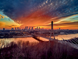 Beautiful panoramic aerial drone sunset view to Warsaw city center with skyscrapers and Swietokrzyski Bridge (En: Holy Cross Bridge) - is a cable-stayed bridge over the Vistula river in Warsaw, Poland
