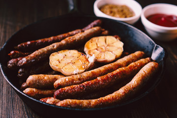 beer and snacks. bar table. restaurant, pub, oktoberfest food. two mugs of craft lager and frying pan with delicious homemade grilled sausages. friday party atmosphere, craft brewery concept