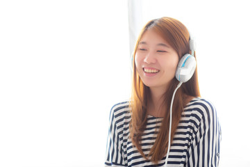 Naklejka premium Beautiful asian young woman enjoy and fun listen music with headphone sitting in bedroom, girl relax with earphone, leisure and technology concept.