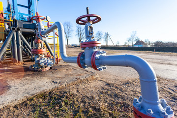 pipe and valve close up next to an aboveground oil producing tower