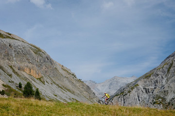 Mountain biker girl in high altitude surrounded by Italian Alps in Livigno Italy