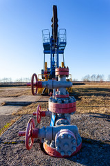 Fototapeta na wymiar pipe and valve close up next to an aboveground oil producing tower