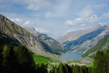 View of a Livigno city and a lake in Italy surrounded by Alps mountains