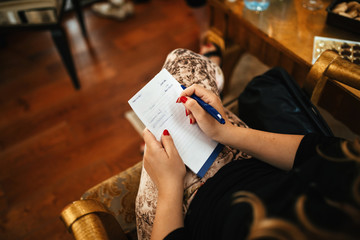 Close up of woman taking notes.