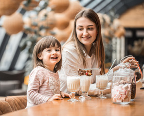 Happy young women mother with children drinking a milkshake