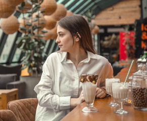 Beautiful Young girl drinking milk chocolate cocktail in a cafe