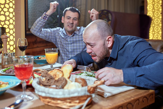 two men in a restaurant arguing during lunch