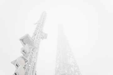 Frozen telecommunication technology tower texture graphics on a foggy winter day