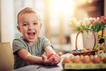 Little boy coloring eggs for Easter holiday