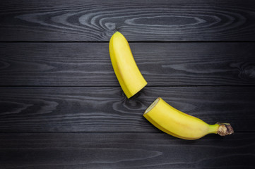 cut in half banana on dark wooden background