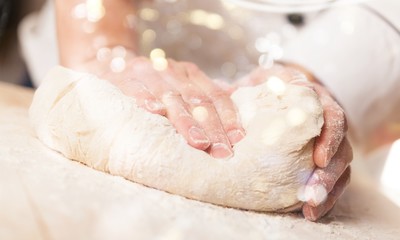Woman's hands knead the dough close up