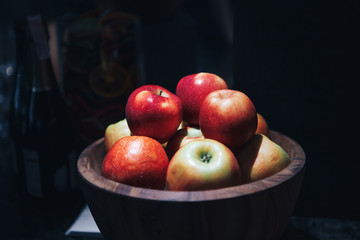 Red apples in a wooden bowl. Black background. close-up