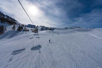 Aussicht von Waidring Steinplatte auf Winterlandschaft mit Schipiste und Schifahrer