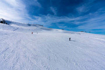 Aussicht von Waidring Steinplatte auf Winterlandschaft mit Schipiste und Schifahrer