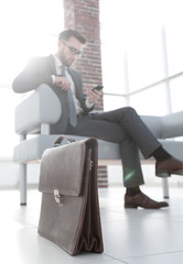 Businessman in his office with briefcase