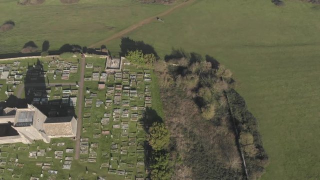 Drone shot of church & graveyard in British countryside