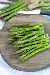 Fresh raw green asparagus vegetable on wooden plank, close up