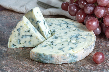 Fourme Ambert semi-hard French blue cheese made from raw cow milk served as dessert with grapes