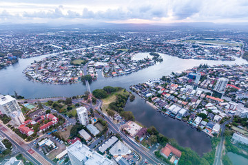 Nerang river flowing around luxury real estate on the Gold Coast at sunset - aerial view