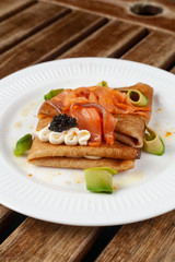 Shrovetide Maslenitsa festival. Russian pancakes blini with avocado, cheese, salmon and caviar
