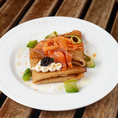 Shrovetide Maslenitsa festival. Russian pancakes blini with avocado, cheese, salmon and caviar