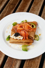 Shrovetide Maslenitsa festival. Russian pancakes blini with avocado, cheese, salmon and caviar