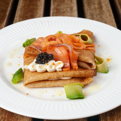 Shrovetide Maslenitsa festival. Russian pancakes blini with avocado, cheese, salmon and caviar
