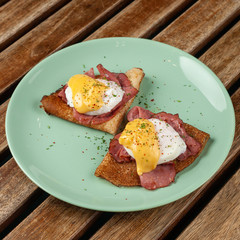 Pancakes with poached egg, ham and cheese sauce