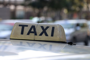 Taxi light sign or cab sign in brown color with black text and tied with wire on the car roof at...