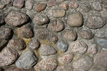 Stone wall texture. Uneven rough surface of granite masonry. Perfect for background and design.