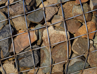 Metal mesh holds many stones. The texture is perfect for background and design.