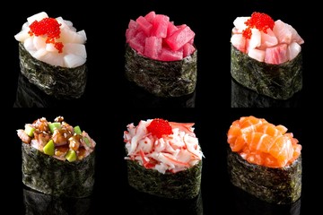 Set sushi gunkan made from tuna, salmon, sea comb, perch, shrimp and smoked eel on black background. Traditional Japanese cuisine