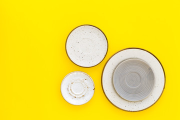 Ceramic plates pattern on yellow background top view space for text