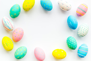 Colorful Easter eggs frame on white background top view copy space