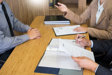 young man explaining about his profile to business managers sitting in job Interview. listen to...