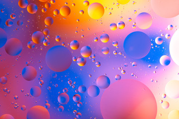 oily drops  in water with colorful background, close-up 