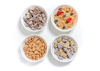 bowls of different breakfast cereals with berries. granola, kashi and cereal chocolate chip cookies on a white background. flat lay, top view