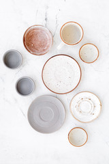 Kitchen concept. Crockery kit. Empty ceramic plates and mugs on white background top view